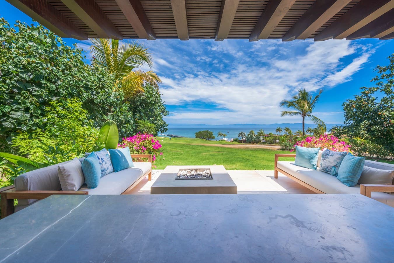 Settle into your private terrace where ocean breezes and vibrant tropical blooms frame sweeping views of lush lawns meeting sparkling turquoise waters—your peaceful paradise awaits.