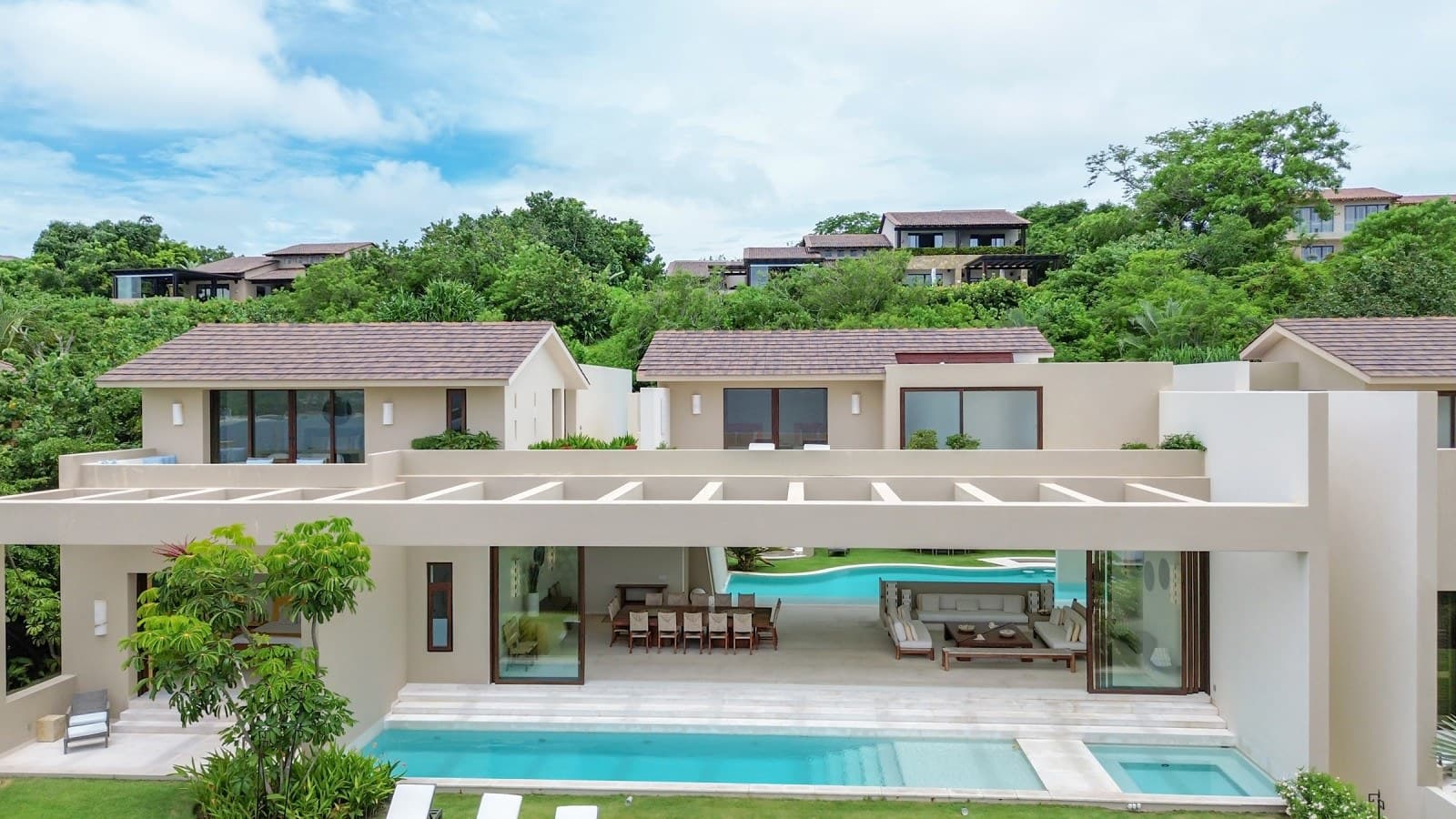 The property is nestled in a lush tropical hillside community, offering a peaceful retreat surrounded by natural beauty and neighboring villas.