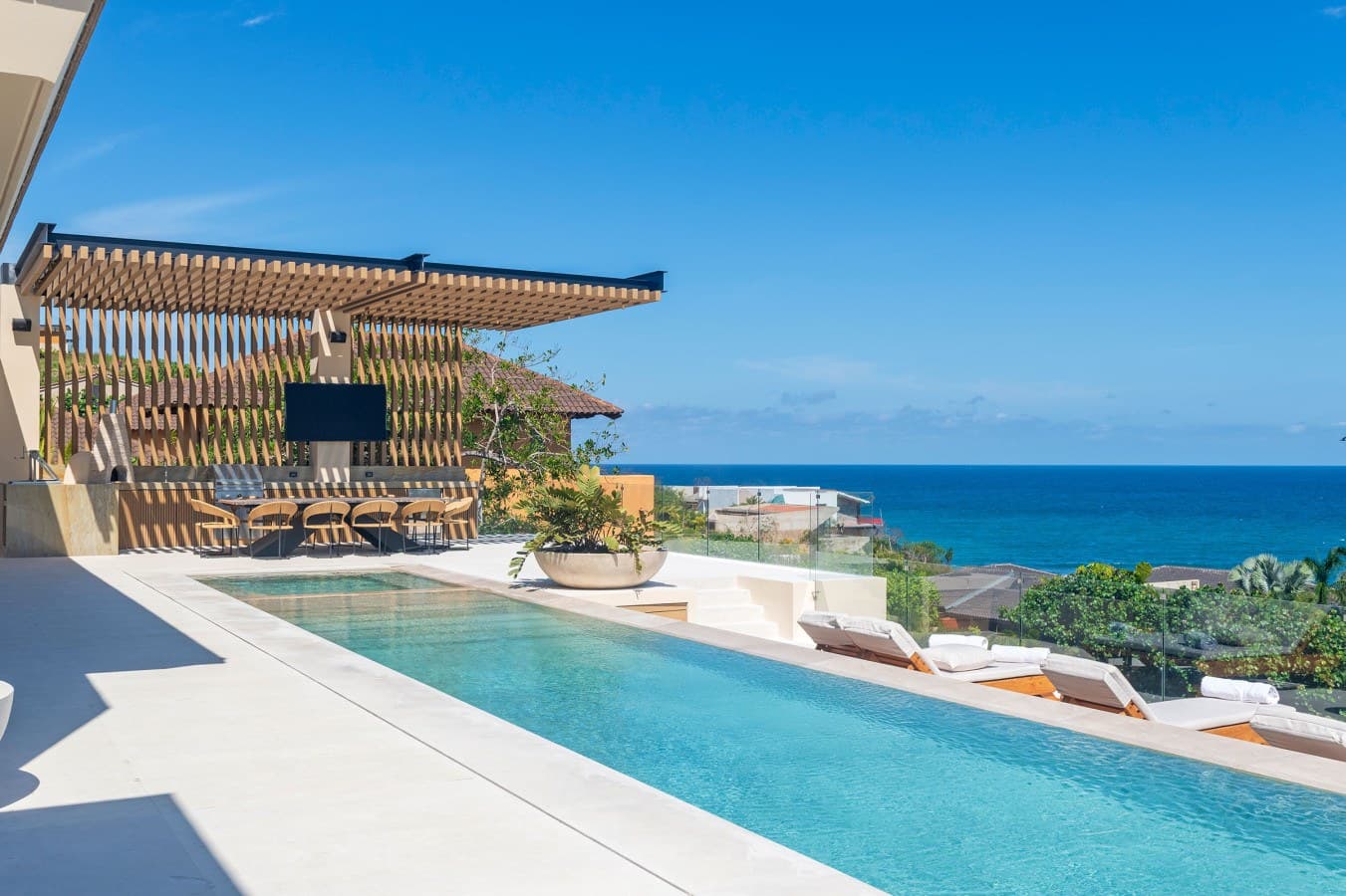 Picture yourself floating in your private pool, watching the endless turquoise horizon stretch before you. Lounge on the sunbeds under the elegant pergola, feel the ocean breeze, and let the coastal beauty envelope your senses.