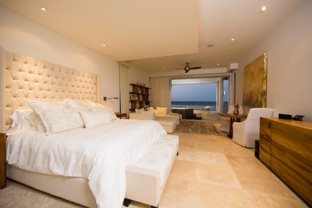 The master bedroom of La Ribera house, with seating by an ocean-facing door.