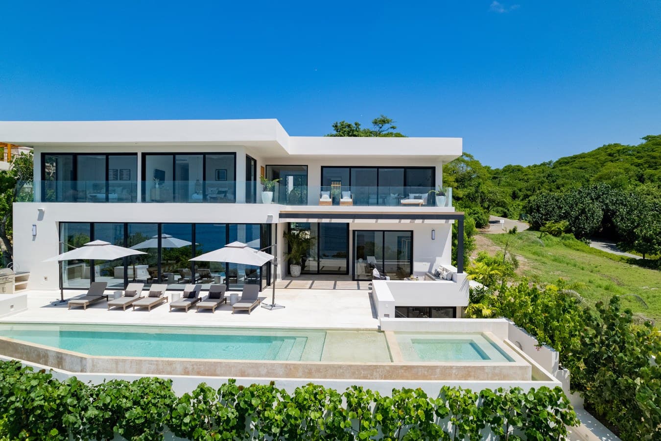 A stunning contemporary villa set amid lush tropical hillside, featuring sweeping natural landscape views and modern architectural design with expansive terraces.
