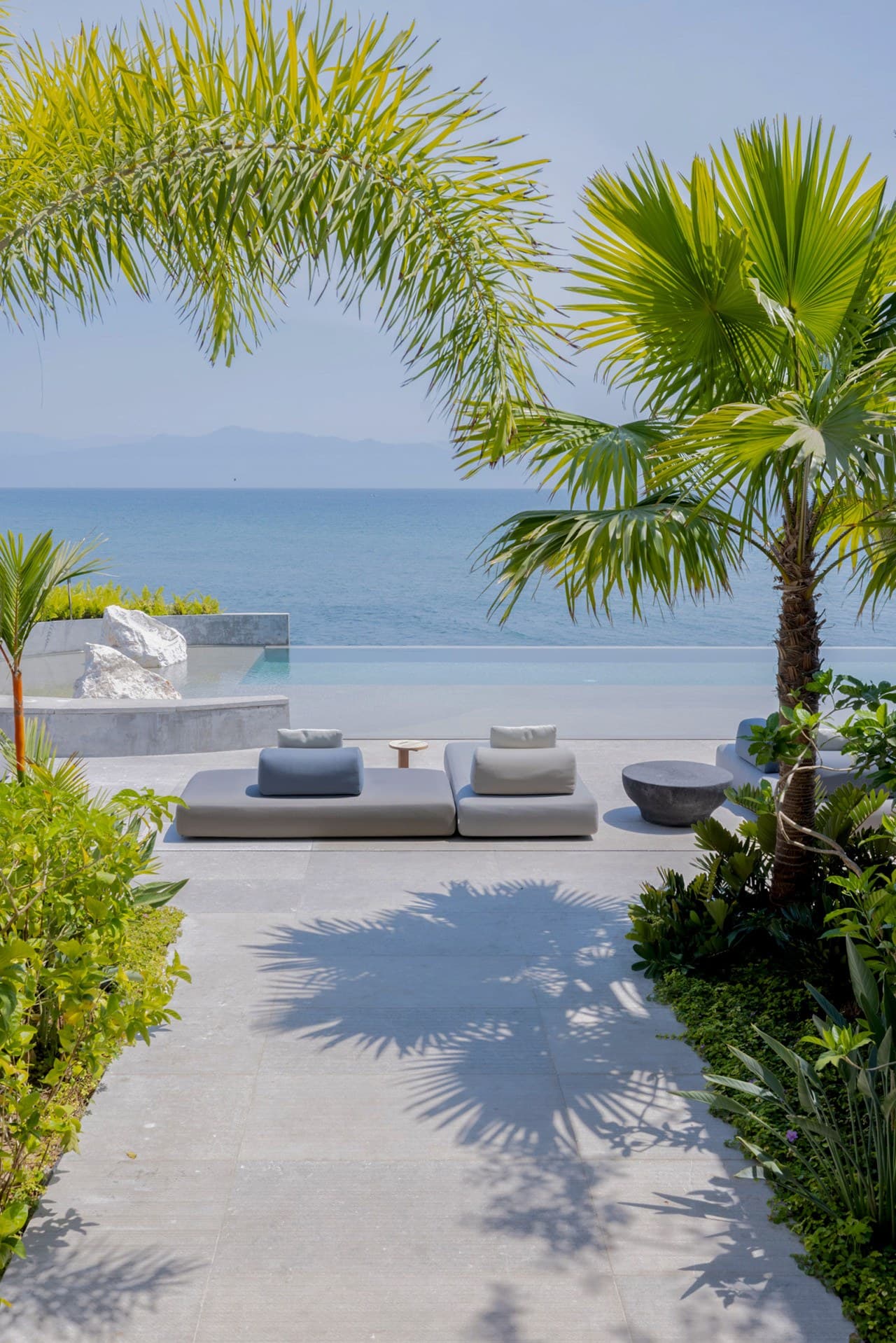 Sink into oceanfront lounging beneath swaying palms, where the infinity pool and sea blend into one breathtaking horizon.