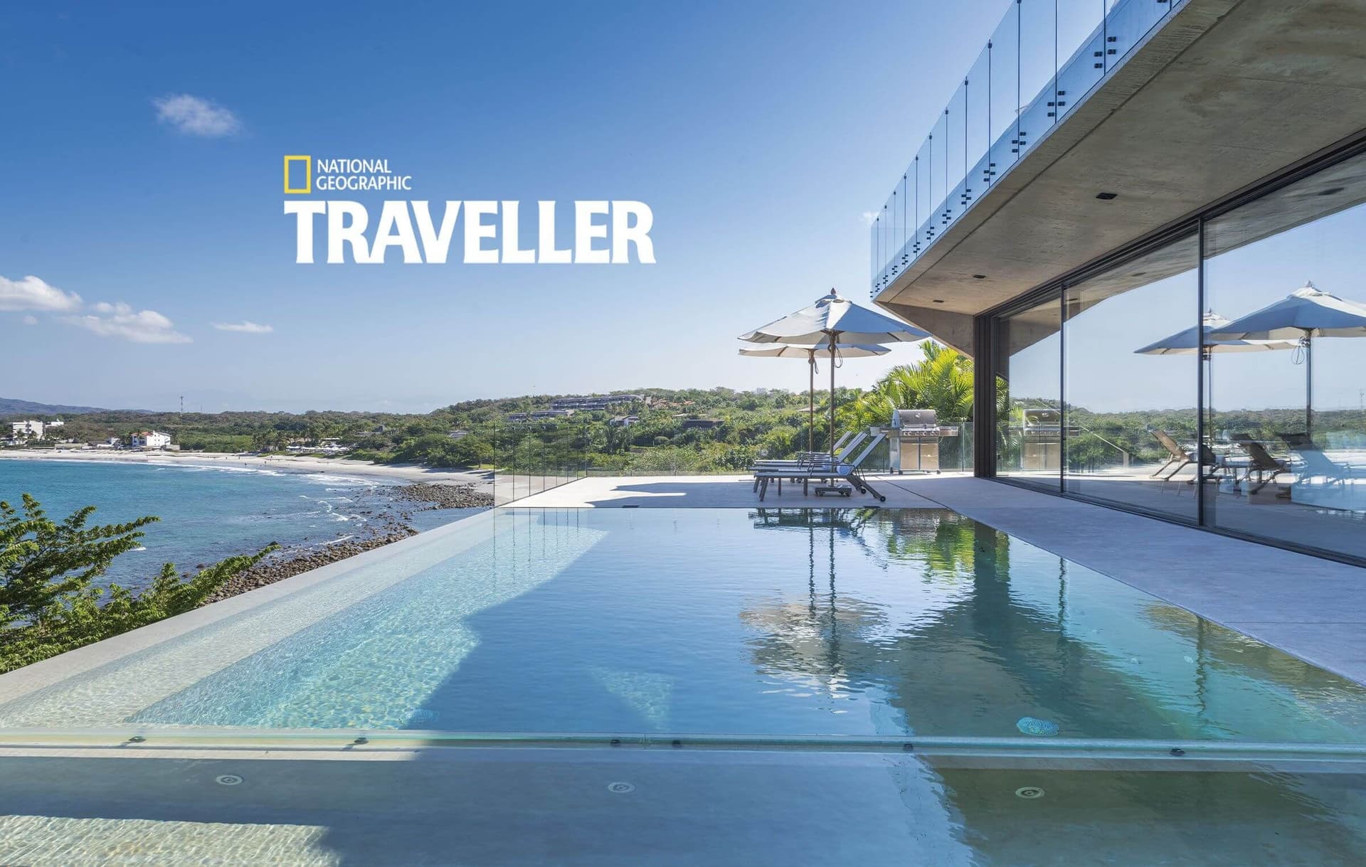 Stunning infinity pool with sunbeds and umbrellas overlooking a coastal bay—your own slice of paradise where azure waters meet the horizon.