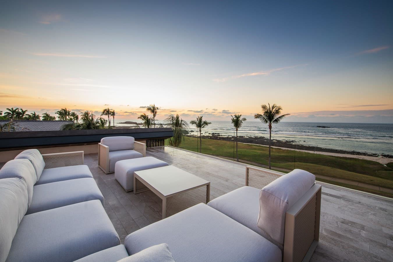 Your private rooftop terrace offers plush seating and an unobstructed ocean vista, framed by swaying palms. Watch the sky transform with golden hues as waves gently roll ashore.