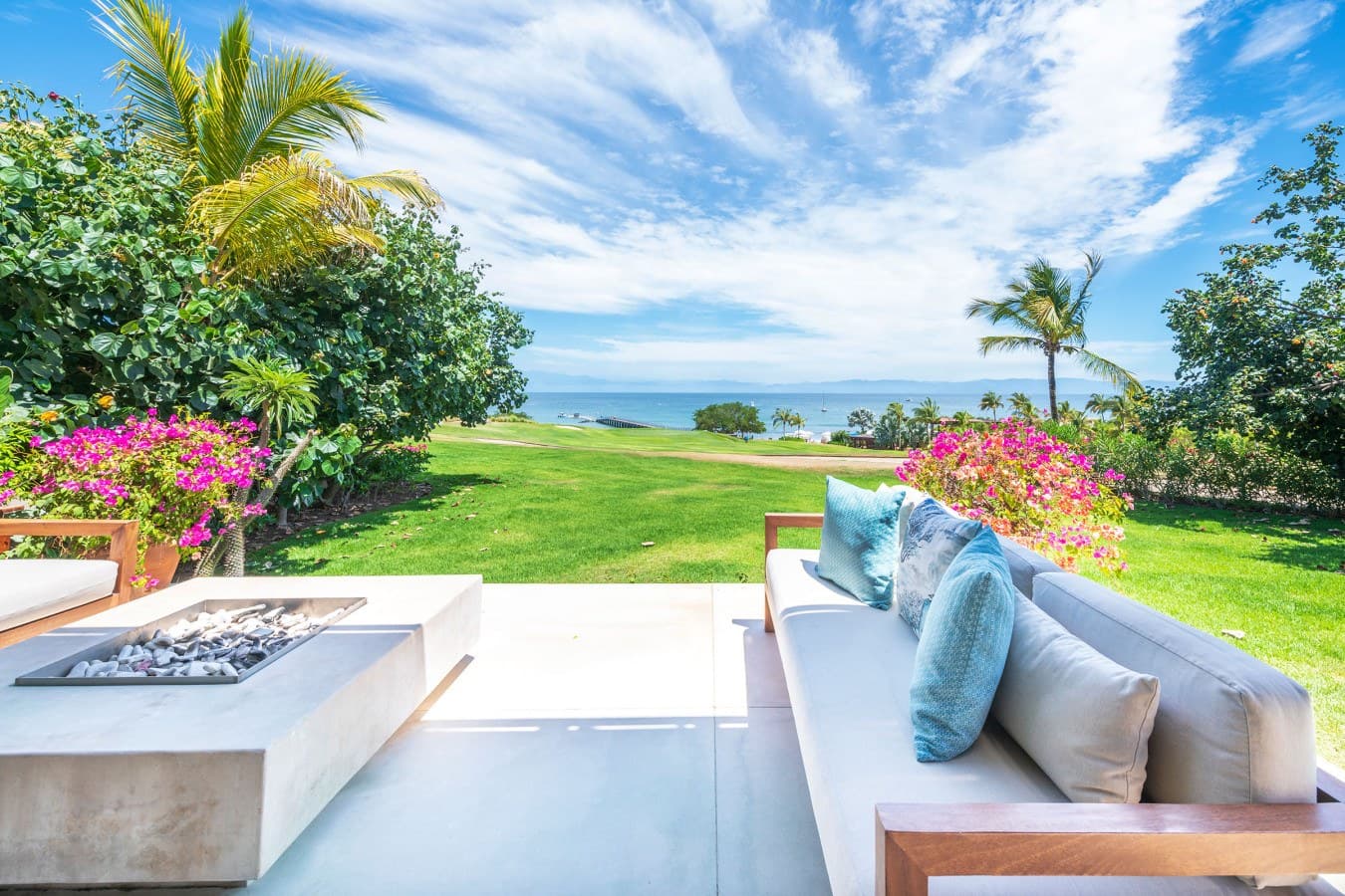 A pristine oceanfront property surrounded by vibrant tropical gardens and lush lawns, set against the serene Hawaiian coastline.