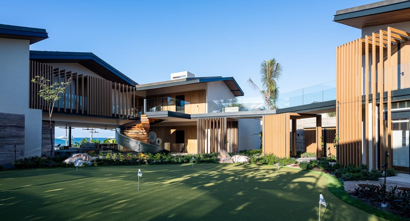 Stunning modern architecture with clean lines and natural wood accents, showcasing the property's distinctive contemporary design and beautifully landscaped grounds.