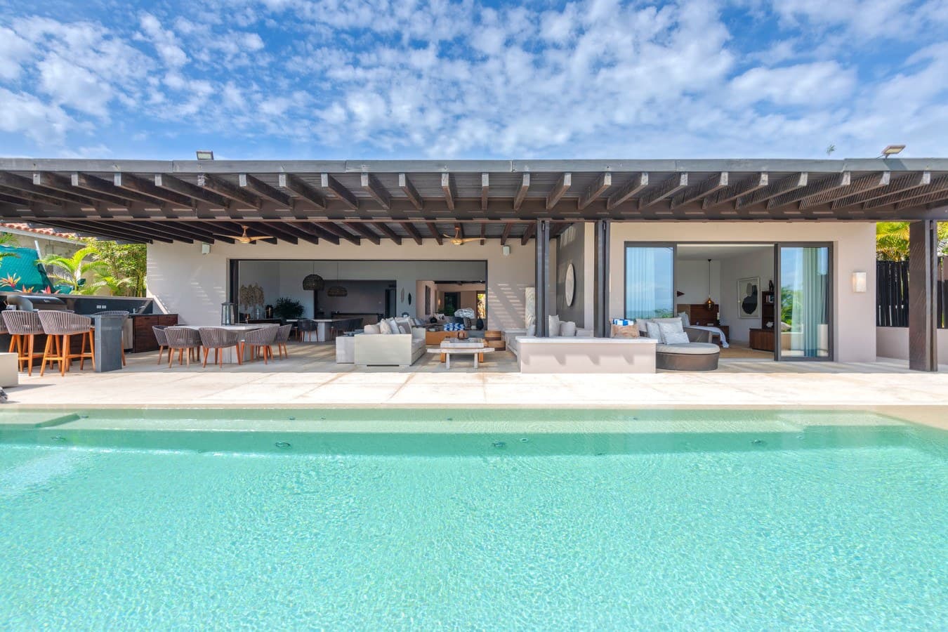 Step into your tropical retreat where the stunning infinity pool blends seamlessly into spacious covered living areas, inviting you to relax and entertain in style.