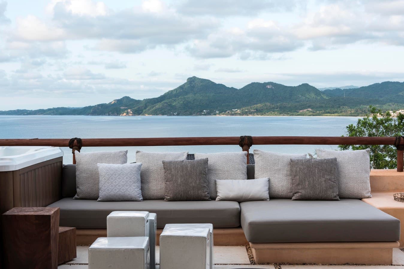 Sink into plush outdoor seating on your private terrace and gaze across tranquil waters toward forested mountain peaks. Your perfect escape awaits.