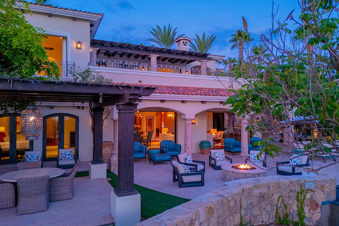 Elevated property showcasing a private pool, lush tropical gardens, and expansive ocean views stretching to distant mountains. A serene coastal setting surrounded by palm trees.