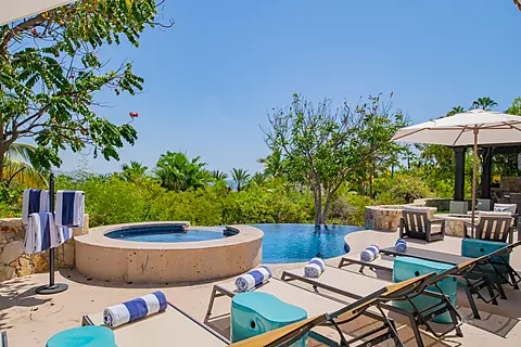 Unwind poolside in your private oasis, where turquoise loungers, a sparkling infinity pool, and a hot tub meet lush tropical gardens and ocean views beyond.