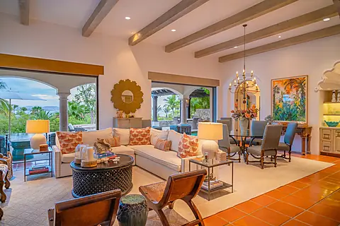 Relax in your spacious living room with exposed beams, curated artwork, and seamless indoor-outdoor flow to the pool and tropical gardens beyond.