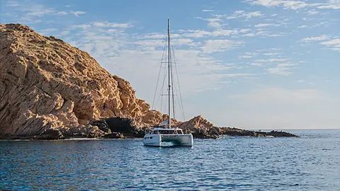 Dramatic coastal cliffs and crystal-clear waters create a stunning Mediterranean backdrop for sailing adventures.