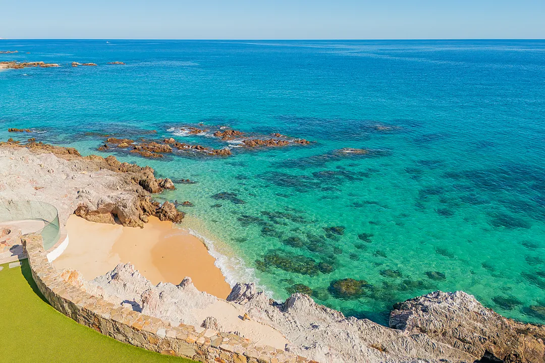 Crystal-clear turquoise waters meet a secluded sandy cove, showcasing the pristine Mediterranean coastline that surrounds this stunning property—a dreamy backdrop to your coastal getaway.