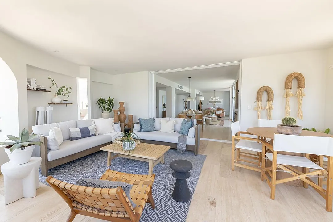 Sink into plush white sofas and coastal-inspired textures in this bright, airy living space where natural light pours through, creating the perfect setting for your beach getaway relaxation.