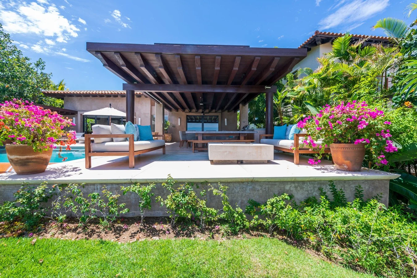A stunning poolside retreat surrounded by tropical gardens and vibrant bougainvillea—perfect for soaking up the sun or unwinding under the shade of your private covered patio.