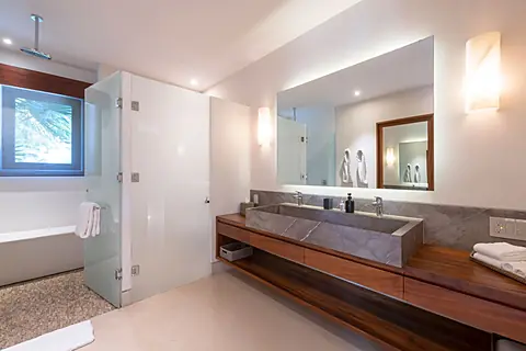 Bathroom 1 (Master ensuite) · Your private spa-like bathroom features a sleek floating vanity, luxurious soaking tub, and rainfall shower—where modern elegance meets total relaxation.