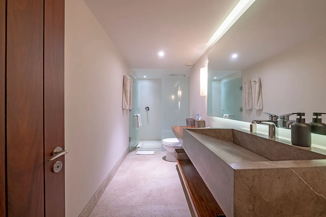 Bathroom 4 · Step into your luxurious bathroom sanctuary with its sleek stone vanity and soothing ambient lighting. Fresh towels await, and your spacious walk-in shower invites you to unwind after a day of adventure.