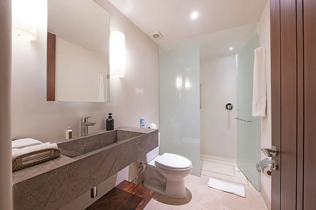 Bathroom 4 · Step into a sleek bathroom with elegant marble countertops, a spacious walk-in shower, and fresh towels ready for your arrival.