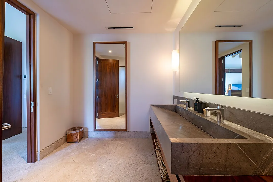 Bathroom 3 · Step into your luxurious bathroom, where a stunning marble double vanity awaits. Warm wood accents and soft lighting create a spa-like retreat with views that extend beyond.
