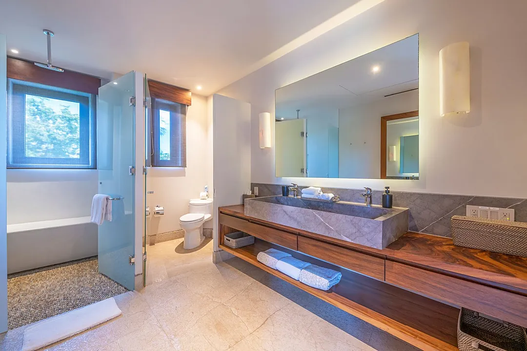 Bathroom 1 (Master ensuite) · Step into your spa-like bathroom, where warm wood tones meet cool stone surfaces. Unwind in the soaking tub, refresh in the glass-enclosed shower, and enjoy thoughtful touches like fresh towels and elegant storage.