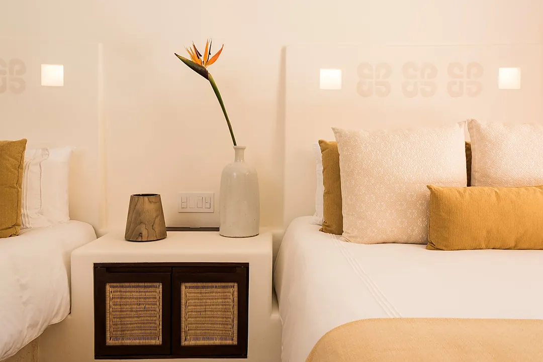 Bedroom 6 · Sink into crisp white linens and plush pillows after a day of adventure. Your peaceful bedroom features warm tropical accents and fresh blooms to help you unwind.