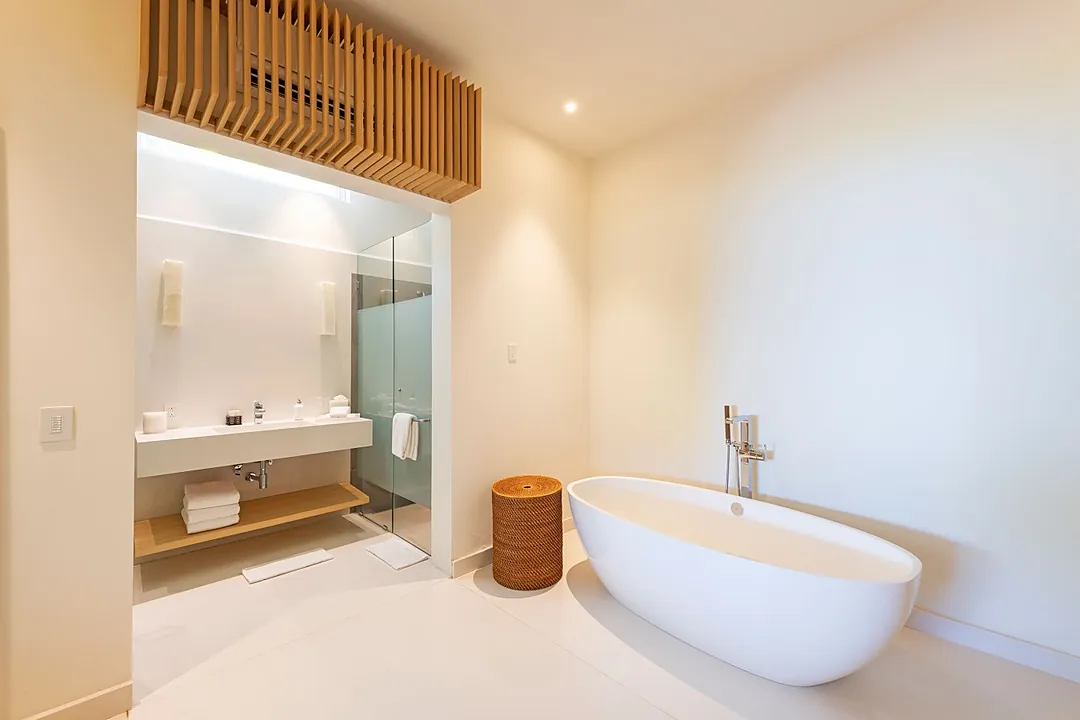 Bathroom 3 · Sink into your private freestanding tub after a long day, or refresh yourself at the sleek vanity—this serene bathroom blends warm wood accents with modern elegance.