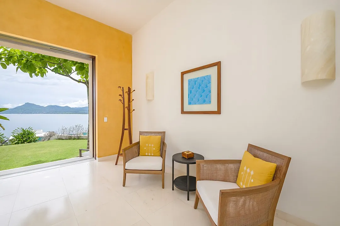 Step into your private kitchen, where sleek modern design meets tropical tranquility. Sunlight streams through the glass doors, revealing lush greenery just beyond, while spacious countertops invite you to prepare your favorite meals in style.