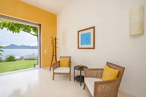 Step into your private kitchen, where sleek modern design meets tropical tranquility. Sunlight streams through the glass doors, revealing lush greenery just beyond, while spacious countertops invite you to prepare your favorite meals in style.