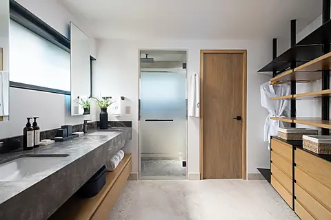 Bathroom 1 (Master ensuite) · Step into your sleek, spa-inspired bathroom where modern design meets comfort. Enjoy the spacious vanity with luxe concrete countertops, a tranquil glass shower, and thoughtful storage for all your essentials.