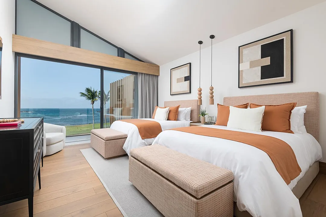 Bedroom 3 · Wake up to the sound of waves and uninterrupted ocean vistas from your private suite. Two plush queen beds dressed in crisp linens invite you to sink in and unwind after beachside adventures.