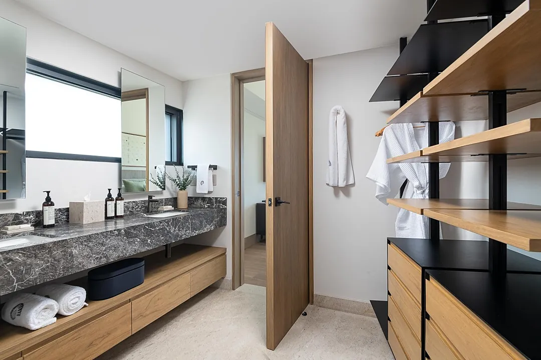 Bathroom 2 · You'll love the sophisticated double vanity with its striking marble countertop and ample storage. Fresh white towels await your arrival, and the thoughtful open shelving keeps your essentials beautifully organized.