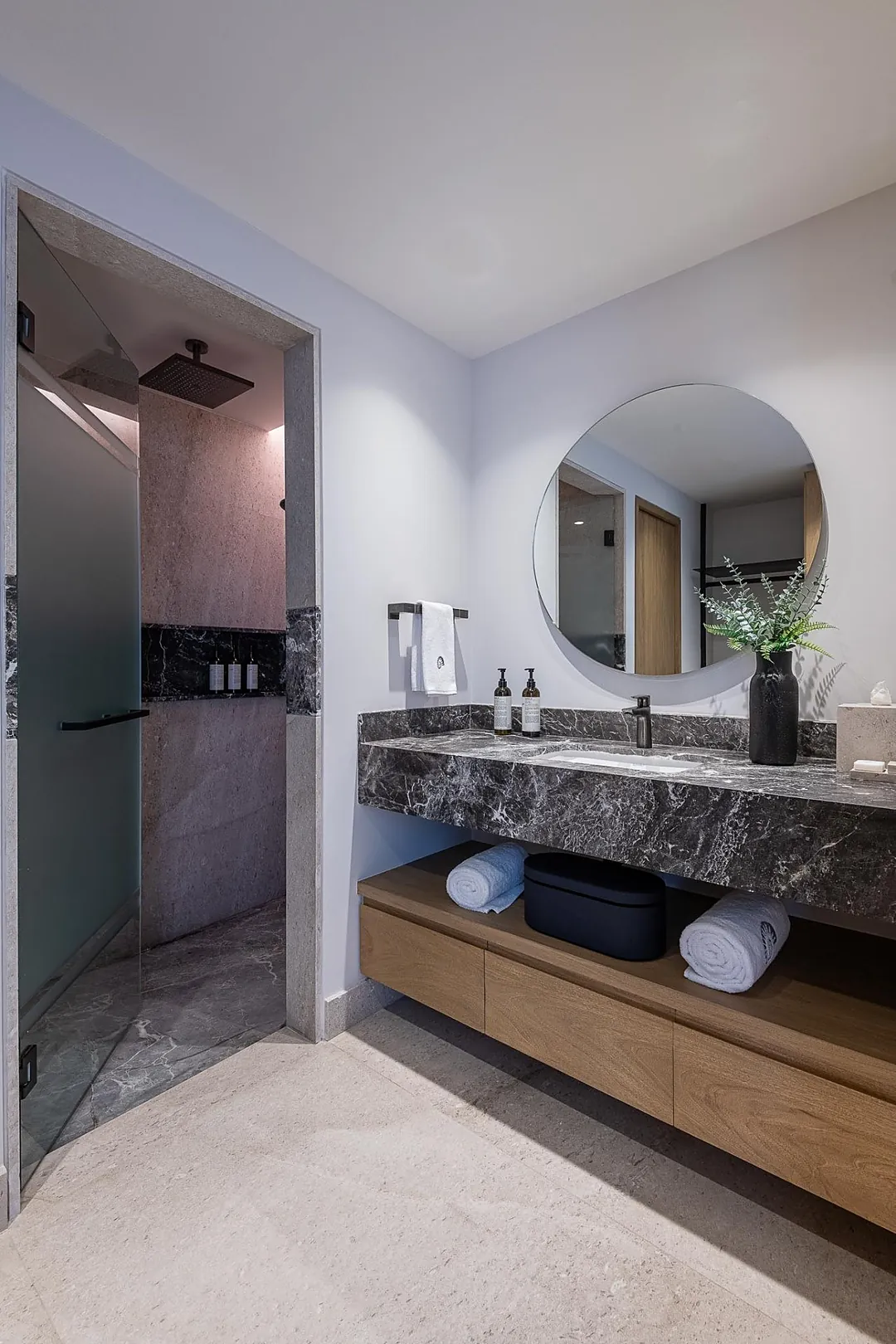 Bathroom 3 · Unwind in your spa-inspired bathroom with elegant marble countertops, a spacious walk-in shower, and thoughtful touches like fresh greenery to help you feel pampered from morning to night.
