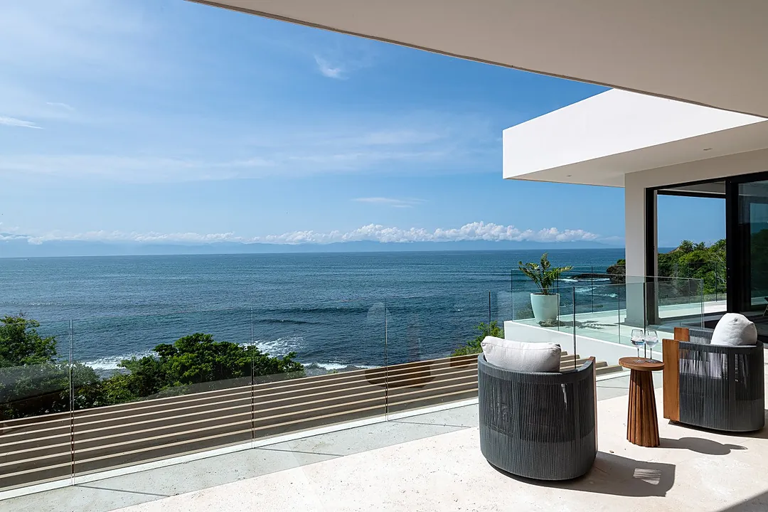 Stunning oceanfront terrace with sweeping views across turquoise waters. Picture yourself relaxing in modern comfort as gentle waves roll in below and endless blue horizons stretch before you.