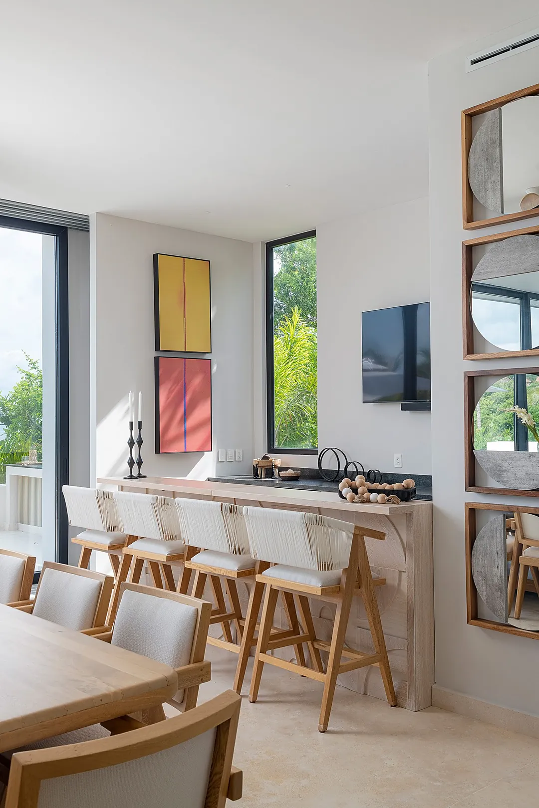 Relax at your private breakfast bar with lush garden views streaming through floor-to-ceiling windows, where modern design meets natural light in perfect harmony.