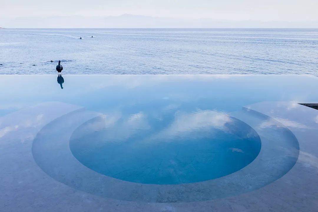 A stunning infinity pool seamlessly merges with the vast ocean beyond, creating a tranquil oasis where you can soak in endless blue horizons and serene coastal beauty.