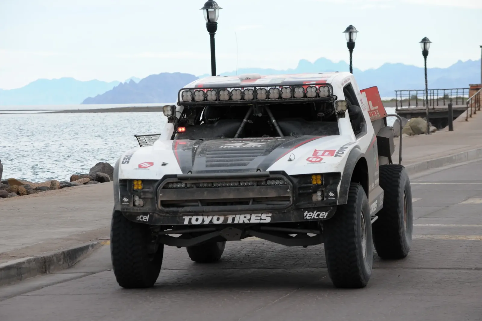 A SCORE trophy truck on the malecon with the Sea of Cortez behind, Baja 1000