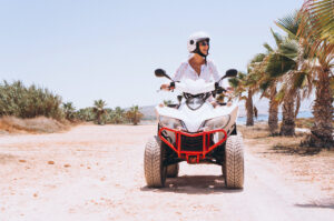 Woman riding a quad by the ocean