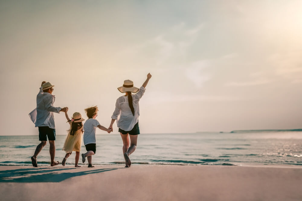 A family on the beach, one of the best things to do with family in Los Cabos.